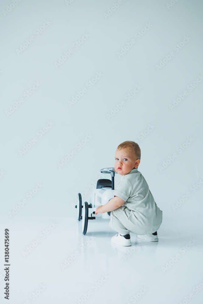 A cute baby is joyfully playing with a toy car in a beautifully minimalist setting that enhances the vibrant colors, showcasing the childs innocence and happiness in a fun and expressive manner