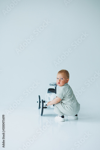 Obraz na płótnie A cute baby is joyfully playing with a toy car in a beautifully minimalist setting that enhances the vibrant colors, showcasing the childs innocence and happiness in a fun and expressive manner w salonie