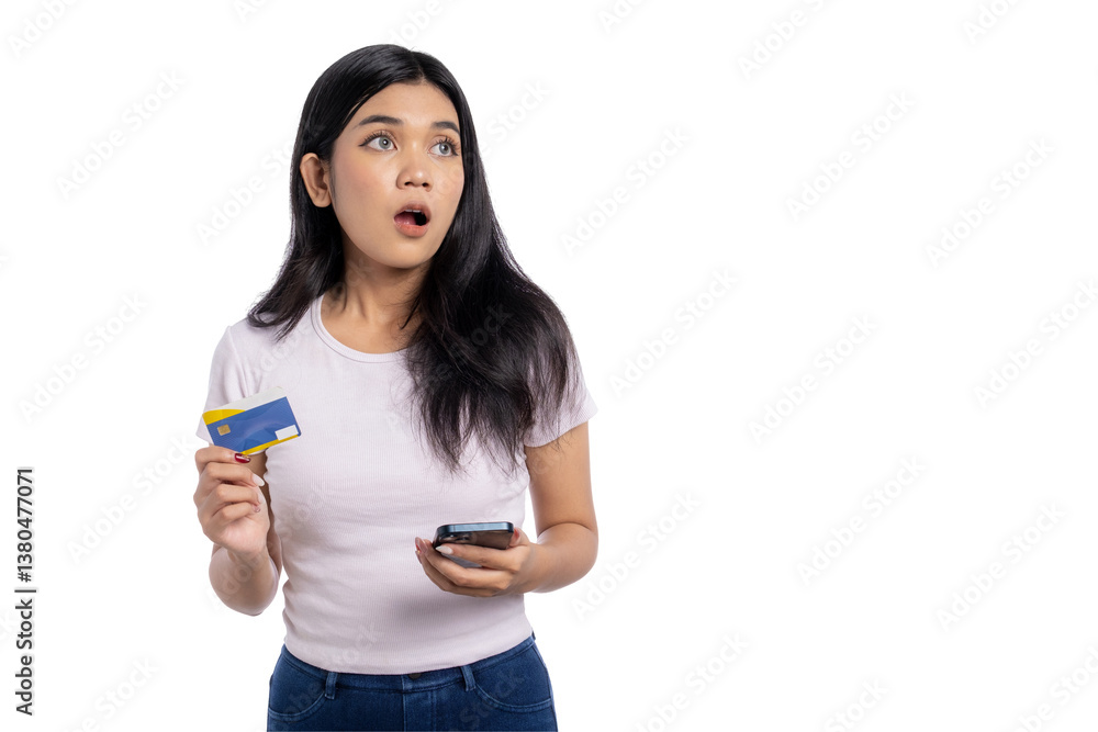 Surprised young Asian woman holding a credit card and smartphone, looking up, isolated on transparent background Surprised young Asian woman holding a credit card and smartphone, looking up, isolated on transparent background