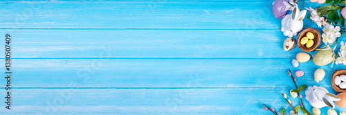 Spring Easter holiday top view flat lay background with eggs, bunny rabbits and spring flowers. Bright colorful greeting card background with copy space.