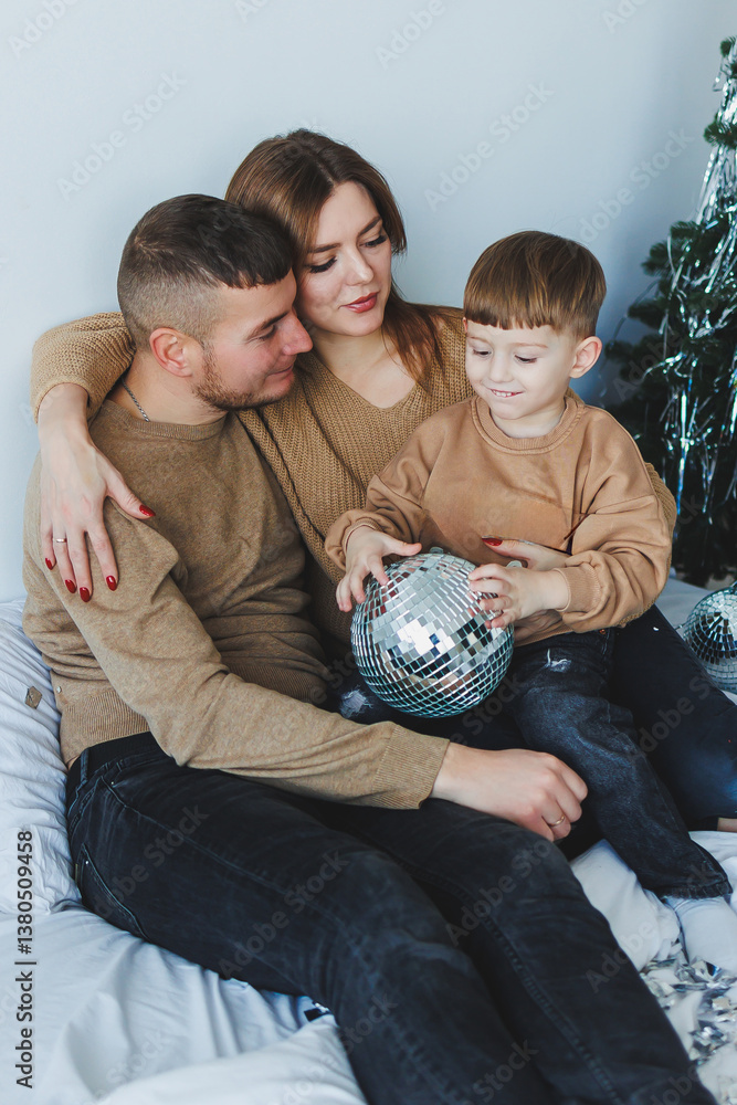 A delightful family portrait that celebrates the essence of togetherness adorned by a shiny disco ball, a perfect touch for the joyous festive season that brings everyone closer and happier