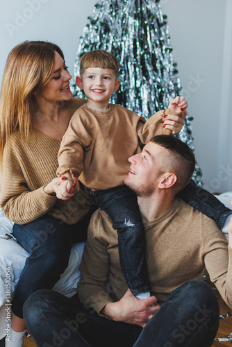 Obraz na płótnie A joyful and heartwarming family portrait captures the essence of togetherness and love as they celebrate near a beautifully decorated and festive Christmas tree, radiating happiness and warmth w salonie