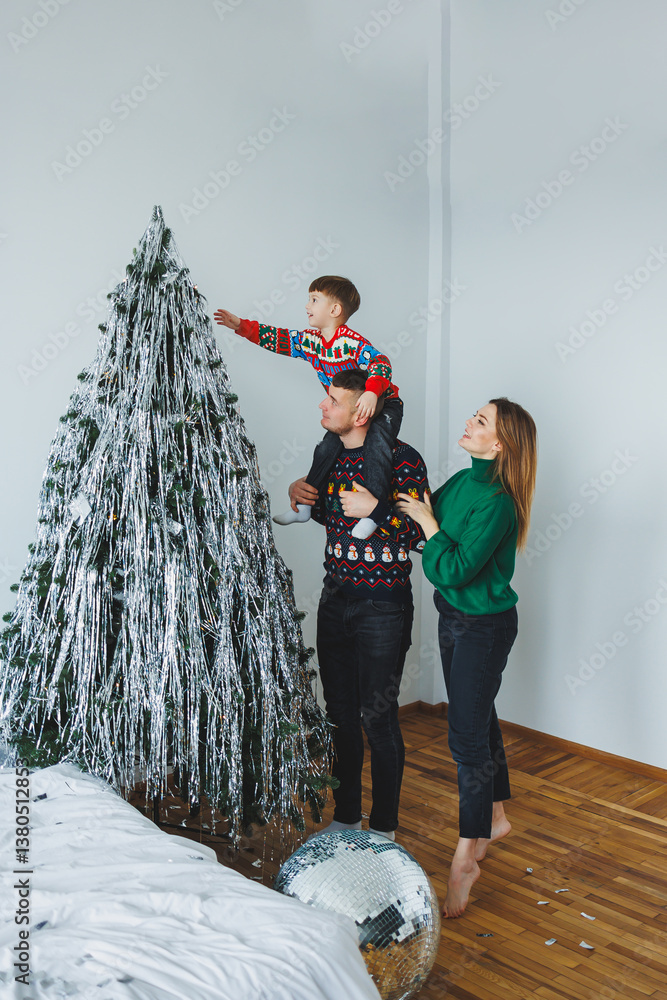 A Family Joyfully Decorating a Christmas Tree Together, Filled with Laughter and Happiness in a Bright and Cheerful Modern Living Space, Creating Beautiful Memories for this Festive Season