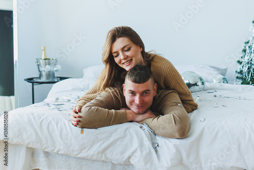 Obraz na płótnie A Joyful Couple Celebrating Their Togetherness in a Cozy Bedroom Adorned with Festive Decor and Surrounded by Warm Embraces, Filling the Space with Cheerful Moments of Happiness and Love w salonie