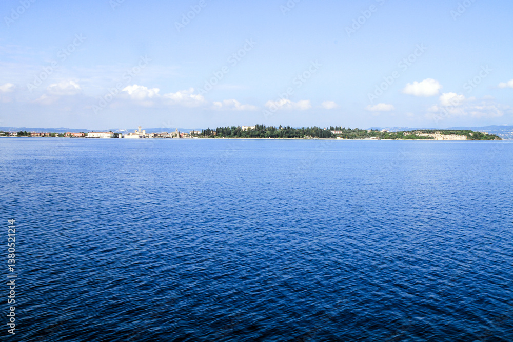 A calm blue lake with a distant shoreline. A calm blue lake with a distant shoreline.