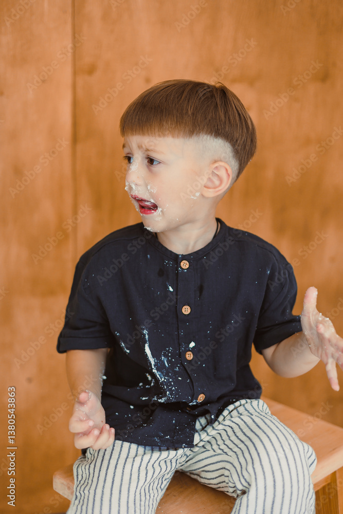 A playful child, with cream smeared all over their face, is fully immersed in enjoying a delightful moment while surrounded by a cozy and welcoming atmosphere that feels just like home
