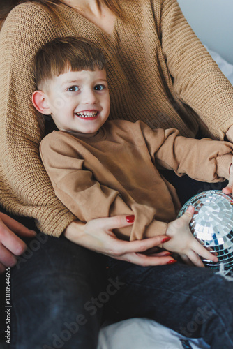 Obraz na płótnie Capturing Joyful Moments A Child Playfully Embraces Fun with a Colorful Disco Ball in a Family Setting Filled with Laughter and Love, Creating Cherished Memories Together That Last a Lifetime w salonie