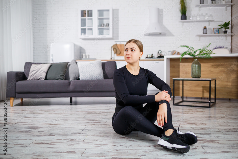 A relaxed female athlete is in a contemporary living space, gracefully performing a variety of stretching exercises that enhance her overall fitness and promote wellbeing, mindfulness, and mobility