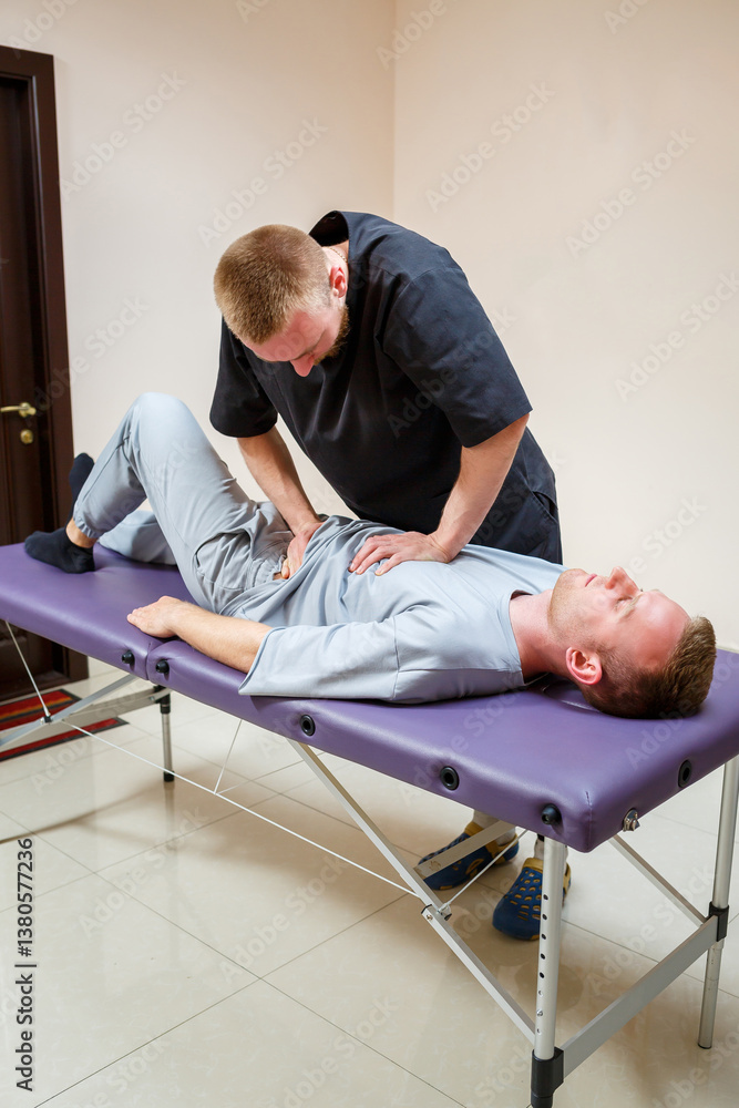 In a dedicated professional physical therapy session, an expert chiropractor skillfully treats a male patient experiencing back pain, aiming to provide effective relief and improve overall wellness