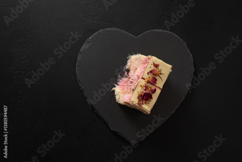 Obraz na płótnie Trendy white chocolate with layer of white and pink pismaniye on heart shaped plate on black background. Tasty dessert. View from above. Copy space. w salonie