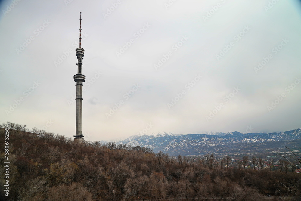 Fototapeta premium Kok Tobe TV tower on a hill with different vegetation. Early spring.