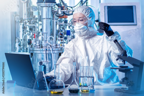 A chemist works in a protec...