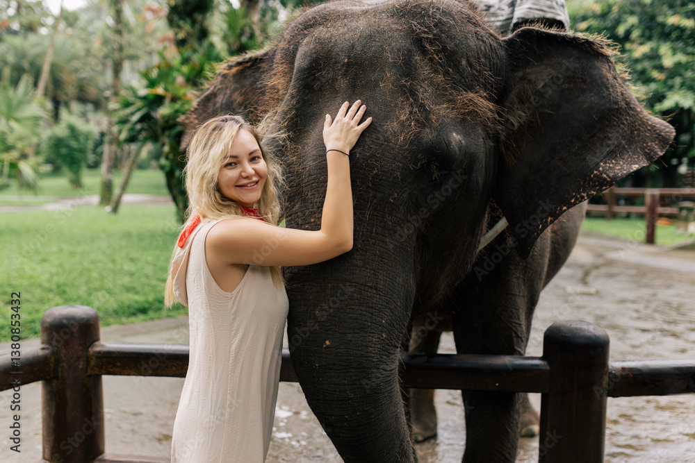 Fototapeta premium beautiful girl with smiling elephant, elephant village, bali