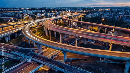 Highway Interchange: A stunning aerial view captures the intricate network of a highway interchange, illuminated at dusk with flowing streams of vehicle light trails.