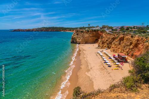 The Algarve beautiful beach with umbrellas sun shades and sun loungers in Portimão Portugal