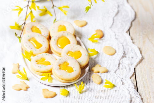 Easter egg cookies with lemon orange curd, covered with white icing and forsythia flowers.