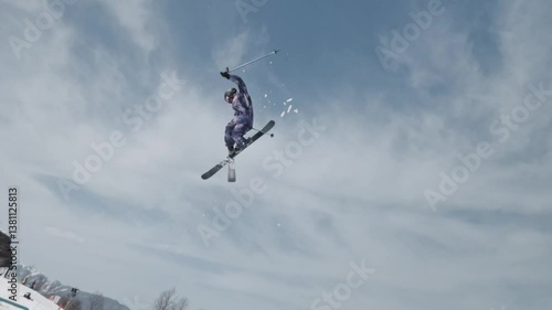 Slow motion close up - Freestyle skier jumping off springboard and doing a spin at snow park. High quality 4k footage