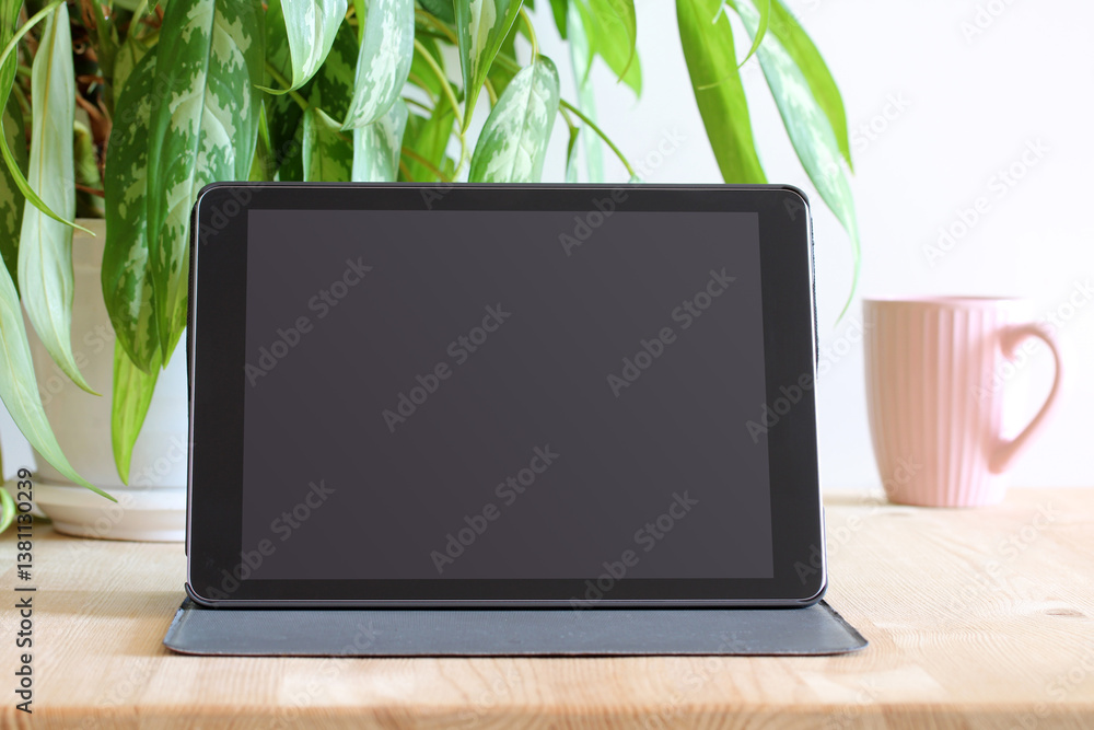 Tablet with blank screen showing potential for advertisement or presentation in cozy home office setting. tablet mockup Tablet with blank screen showing potential for advertisement or presentation in cozy home office setting. tablet mockup