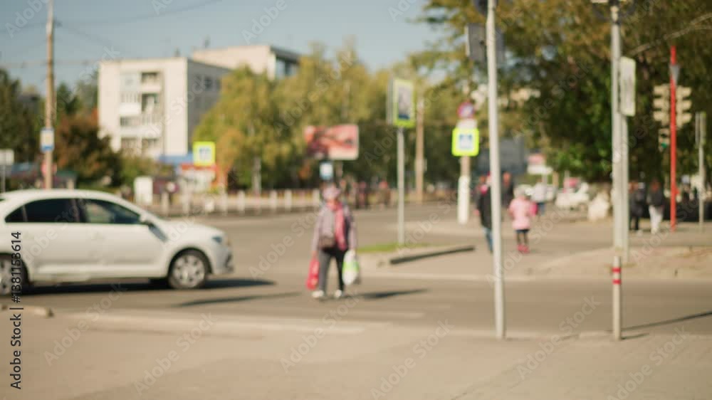 Blurry view of busy road with pedestrians and cars moving. Trees and street signs visible in background. Urban setting with vibrant city life, busy traffic, and dynamic pedestrian movement Blurry view of busy road with pedestrians and cars moving. Trees and street signs visible in background. Urban setting with vibrant city life, busy traffic, and dynamic pedestrian movement