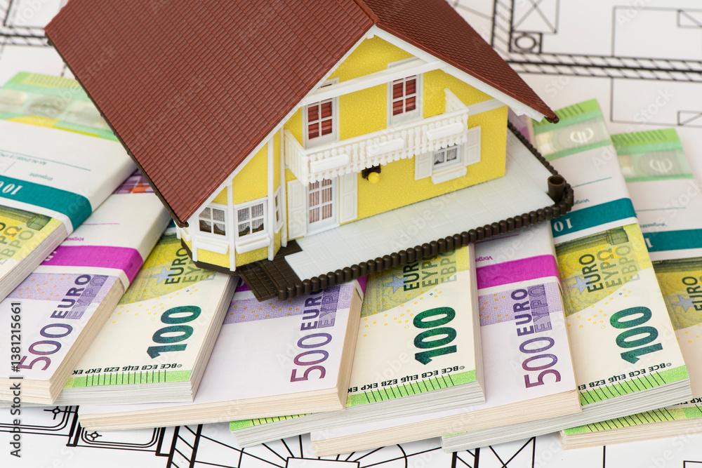 Ein Modellhaus steht auf vielen Euro Banknoten als Symbol für die Baufinanzierung