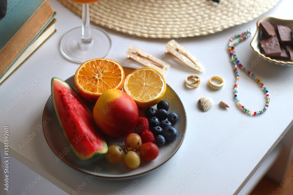 Glass of cocktail, straw hat, sunglasses, books, fresh fruit, chocolate and accessories. Summer essentials on the table. Selective focus.