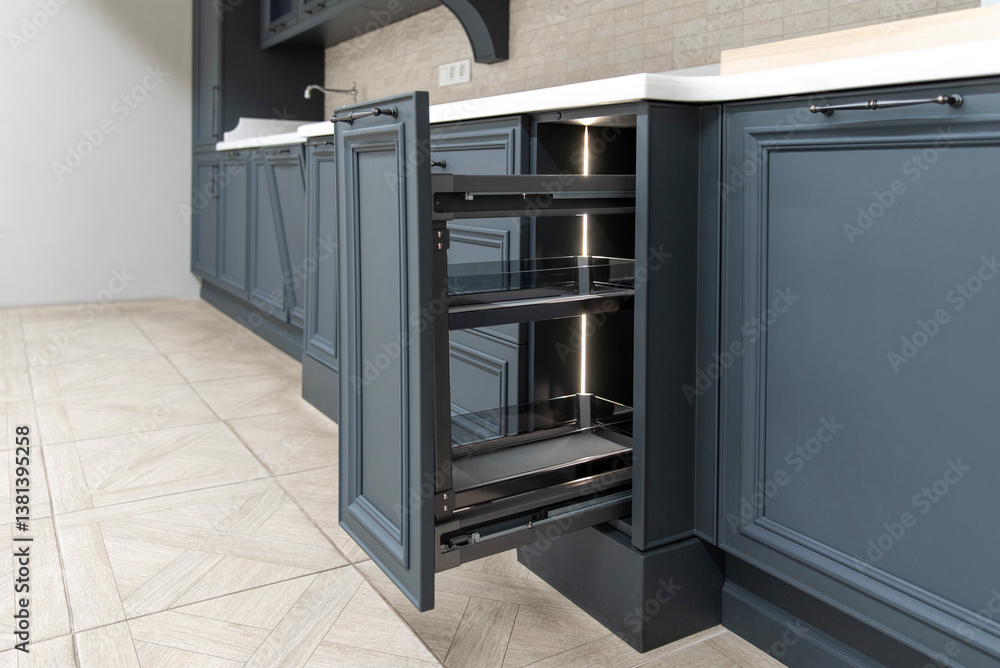 Open deep drawer in a classic dark blue kitchen interior Open deep drawer in a classic dark blue kitchen interior