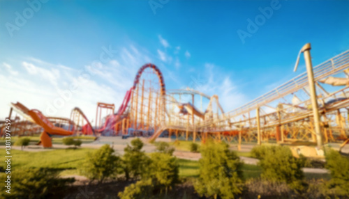A blurred amusement park scene captures the essence of thrill and excitement, featuring a roller coaster against a backdrop of a bright blue sky. A blurred scenery to be used as background.