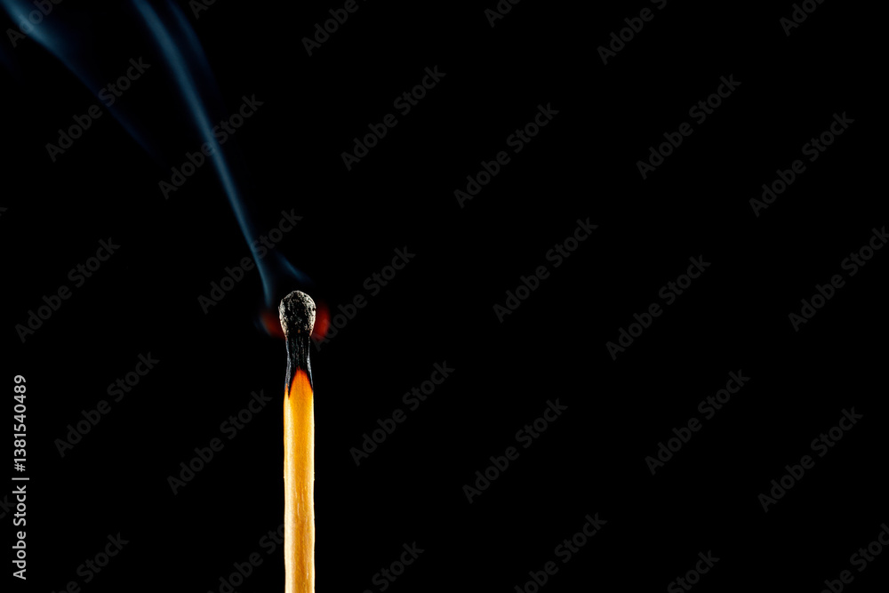 A burning match with smoke on a black background. Space for text. A burning match with smoke on a black background. Space for text.