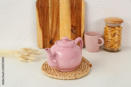 Pink ceramic teapot on wove...