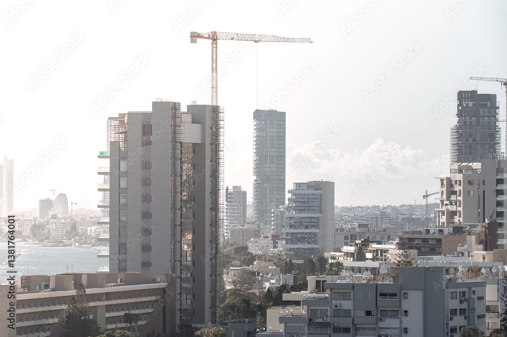 Fototapeta premium Construction crane building a modern skyscraper in Limassol city, Cyprus