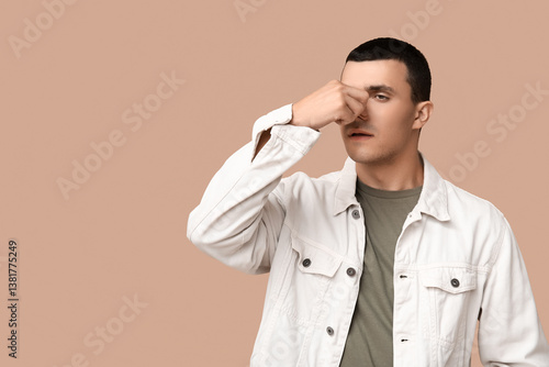 Ill young man blowing nose ...