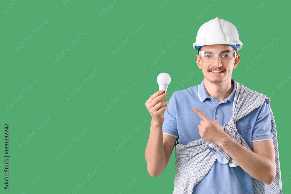 Male worker pointing at light bulb on green background Male worker pointing at light bulb on green background