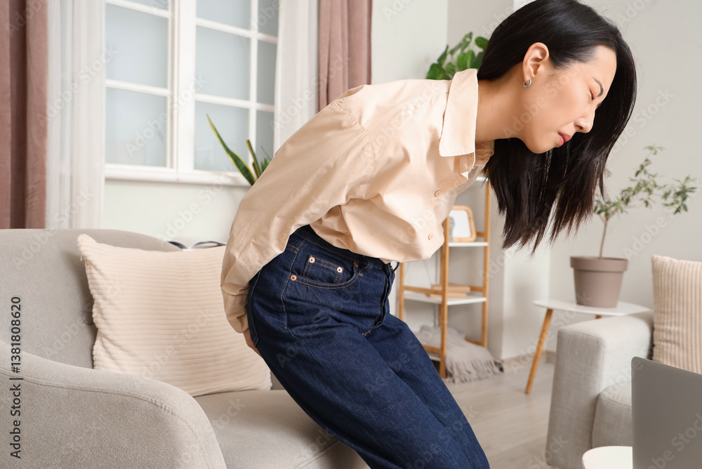 Young Asian woman with hemorrhoids at home