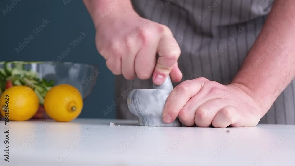 man making seasoning in the mortar , adding salt and pepper man making seasoning in the mortar , adding salt and pepper