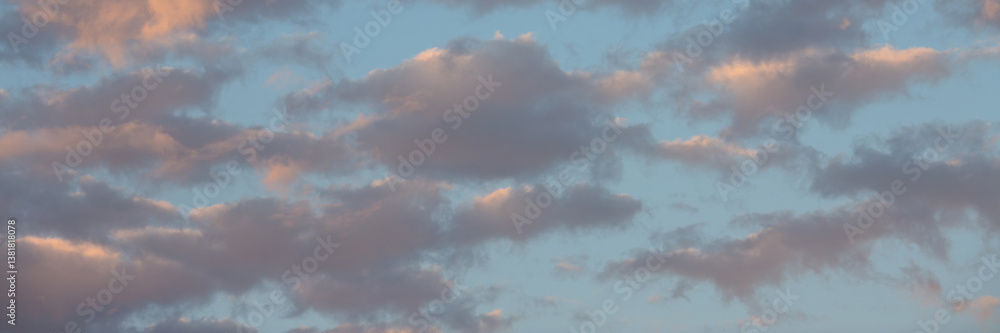 Beautiful sunset sky background with clouds. Scenic cloudscape. Wide panoramic background for design.