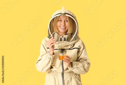 Female beekeeper with jar o...