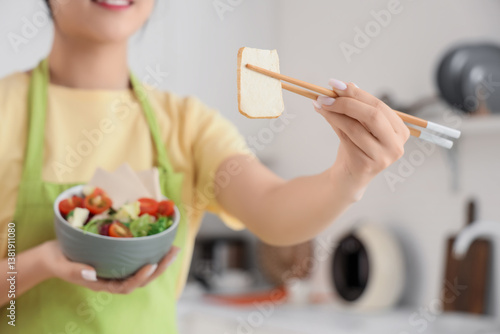 Young Asian woman eating ta...