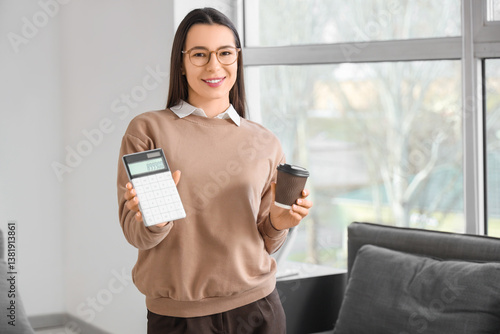 Obraz na płótnie Young businesswoman with calculator and coffee cup in office w salonie