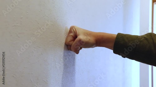 壁に突き当てられる拳