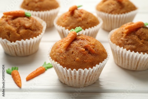 Tasty carrot muffins on white wooden table, closeup