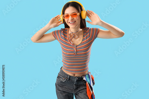 Beautiful young woman in rainbow t-shirt on blue background. LGBT concept