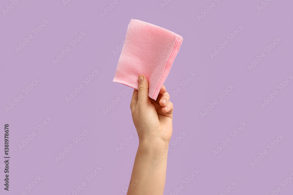 Female hand with pink paper napkins on lilac background