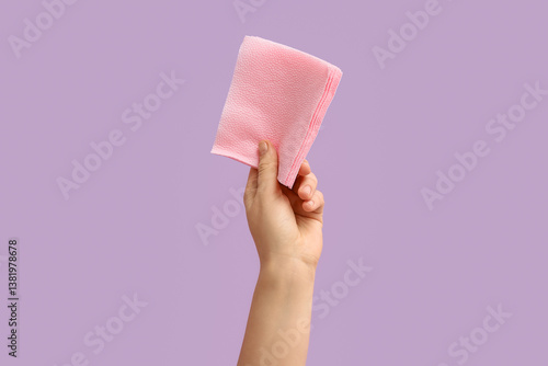 Obraz na płótnie Female hand with pink paper napkins on lilac background w salonie