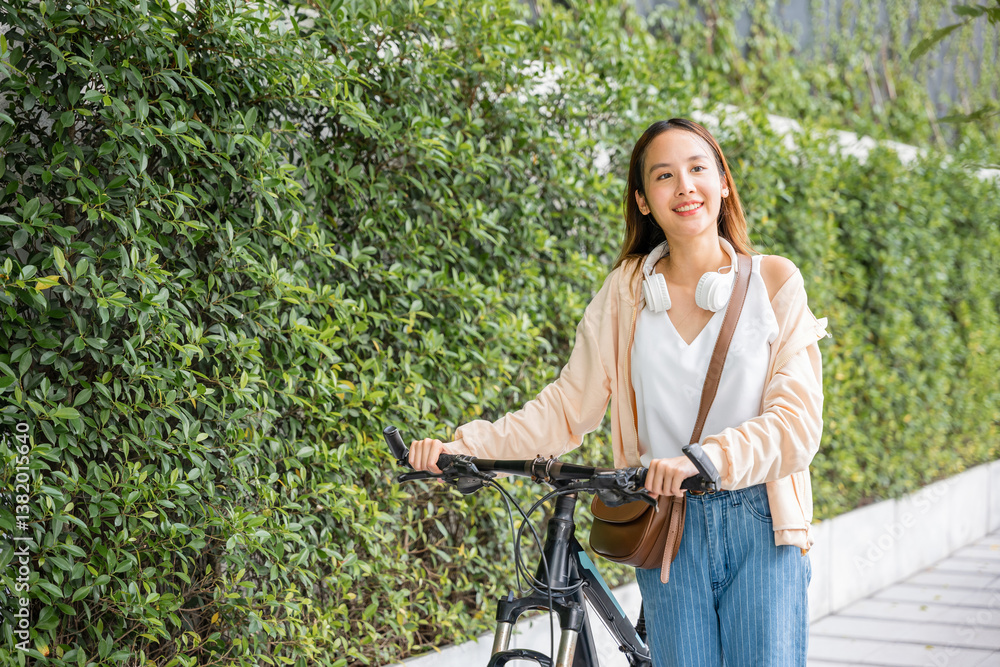 Fototapeta premium Lifestyle Asian young woman walking alongside with bicycle on summer in countryside outdoor, Happy female smiling walk down the street with her bike on city road, ECO environment, healthy travel