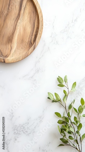 Obraz na płótnie A wooden plate rests on a marble surface, accompanied by a sprig of green leaves, creating a serene and natural aesthetic. w salonie