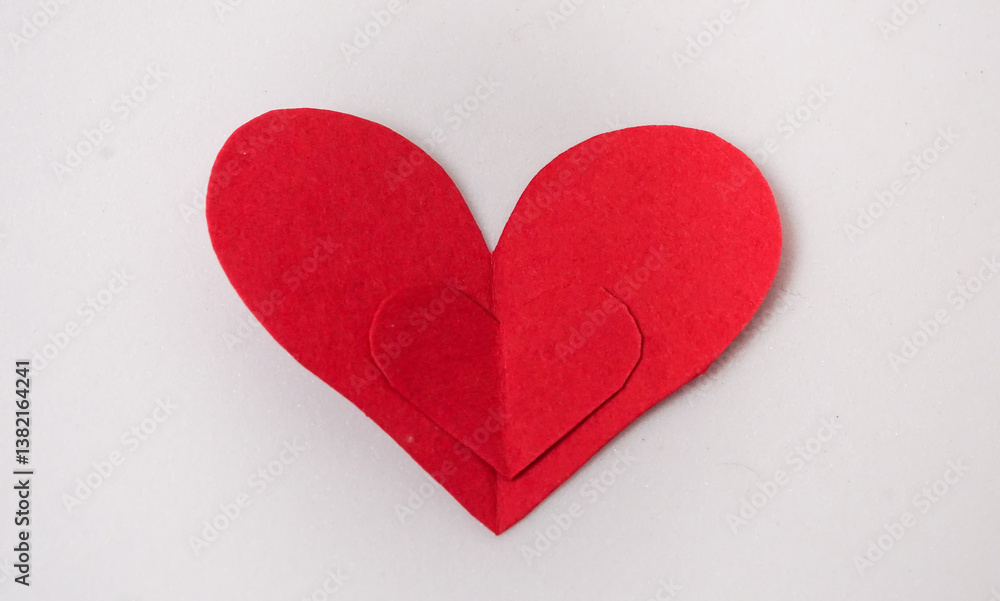 Obraz premium Red paper Valentines Day heart against a white background, love concept. Flat lay