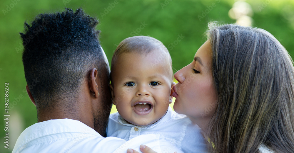 Fototapeta premium Mothers kissed Biracial baby. Close up portrait of mother kissing baby. Mother kiss child, father caring baby. Closeup face of Mother with Biracial baby kissing. Tender kiss. Mother kiss and love.