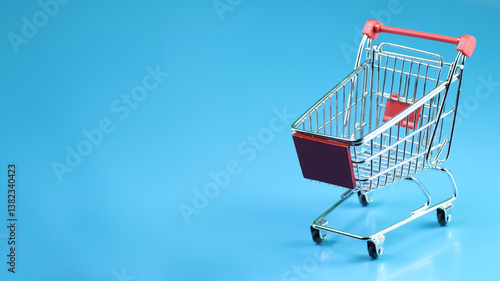 a miniature shopping cart in horizontal blue background