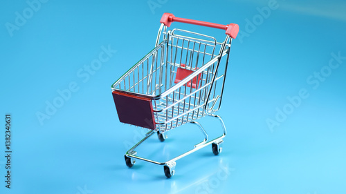 a miniature shopping cart in horizontal cyan blue background