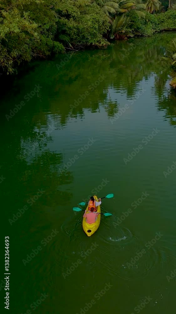 Paddling through serene waters surrounded by vibrant greenery, an adventurer enjoys a peaceful kayak ride in Thailand. The lush landscape enhances the tranquility of the experience. Paddling through serene waters surrounded by vibrant greenery, an adventurer enjoys a peaceful kayak ride in Thailand. The lush landscape enhances the tranquility of the experience.